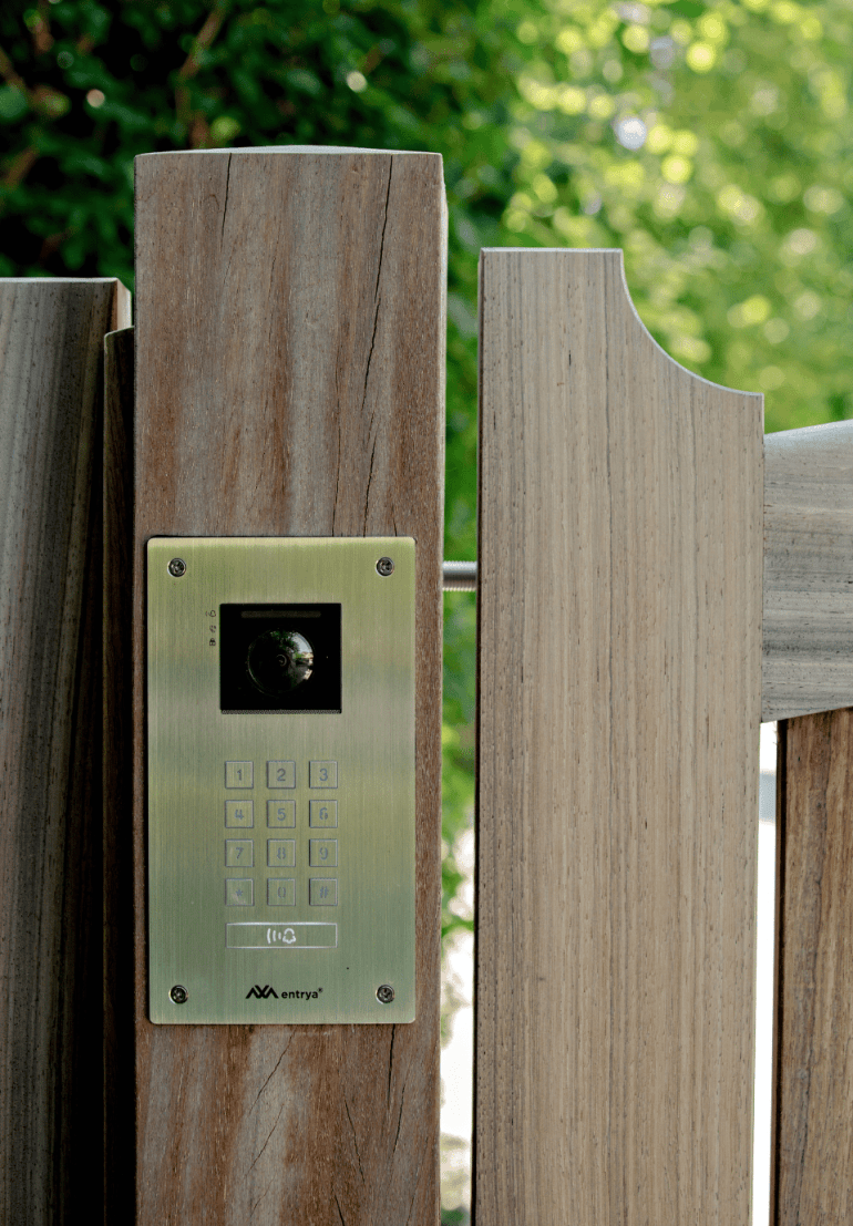An intercom system with a video attached to a wooden residential gate