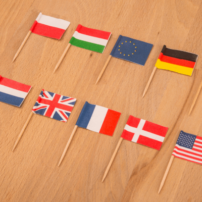 Miniatuurvlaggen van verschillende landen op een houten tafel.