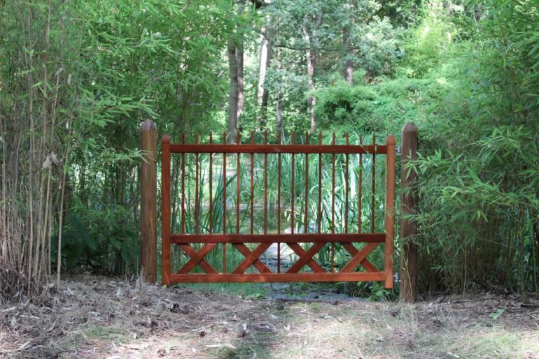 Een houten poort midden in een bos.