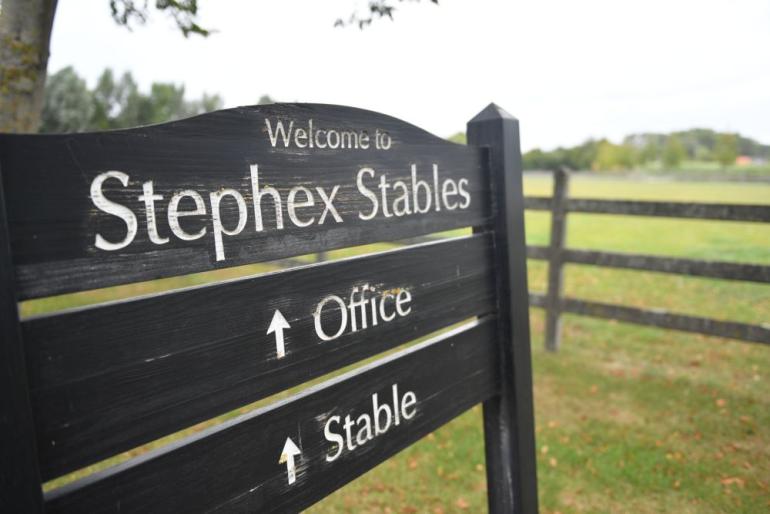 Stephex Stables uithangbord en houten hekken met vierkante palen erachter