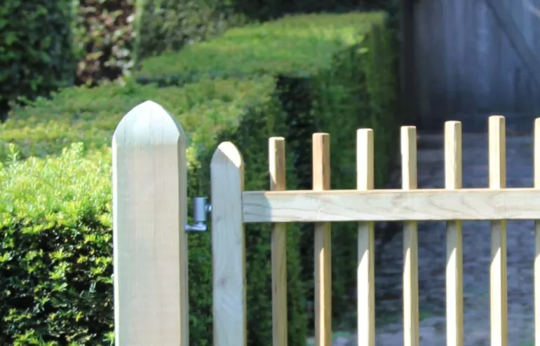 Cottage wooden gate with narrow vertical posts.