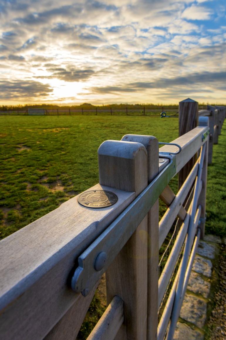 Een close-up van het beslag van een houten poort op een veld