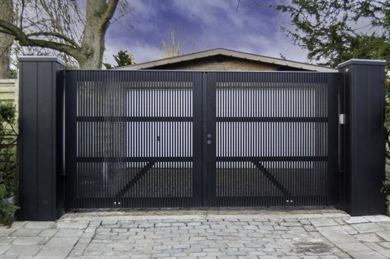 Un portail pivotant en bois noir avec un motif transparent, fixé à deux poteaux en bois noir.