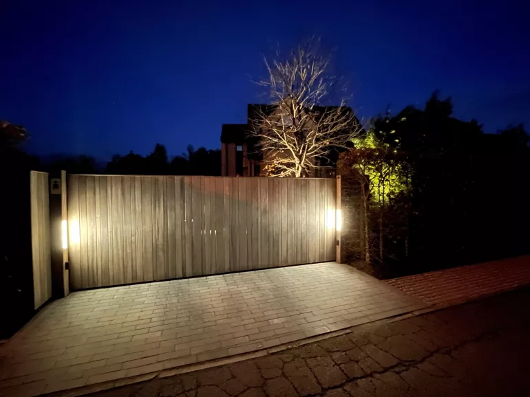 Een houten schuifpoort met led-verlichting aan de zijkanten