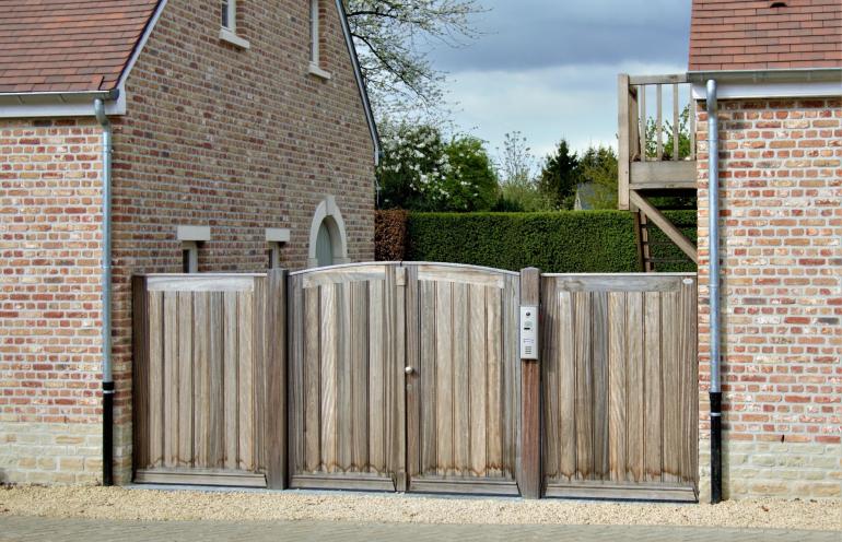 Une double porte en bois pour votre jardin avec un système d'interphone intégré