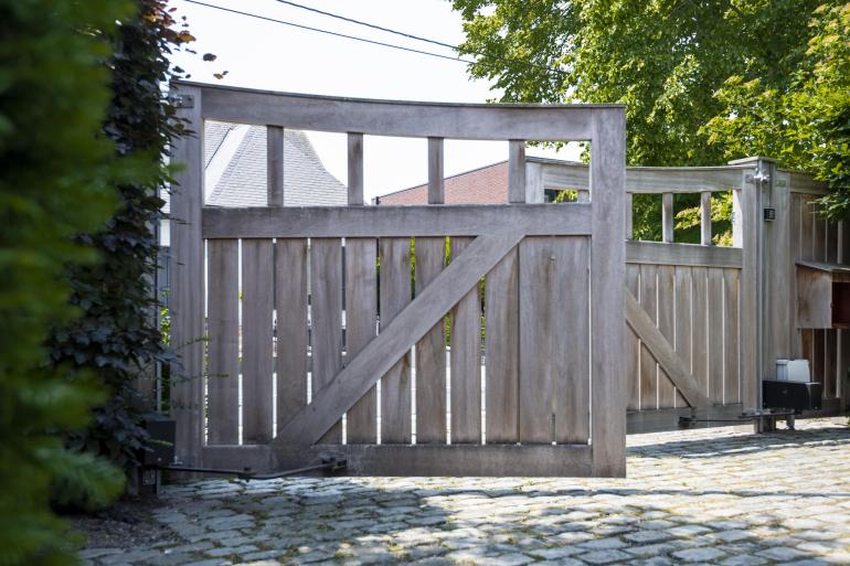 Un portail battant en bois avec des carrés ouverts au sommet
