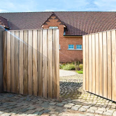 Een houten draaipoort voor de oprit met een intercom- en videosysteem