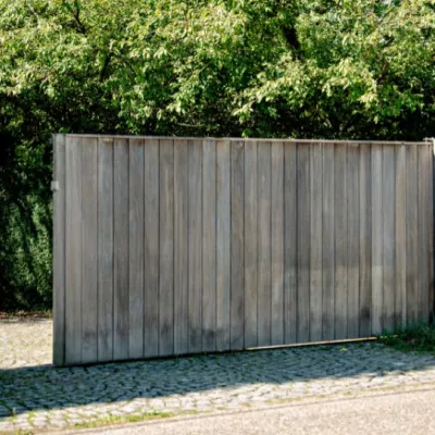 Een houten schuifpoort met een intercom- en videosysteem
