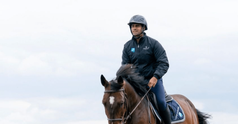 Yoann Di Stefano of CY farm rides a horse beside a lake