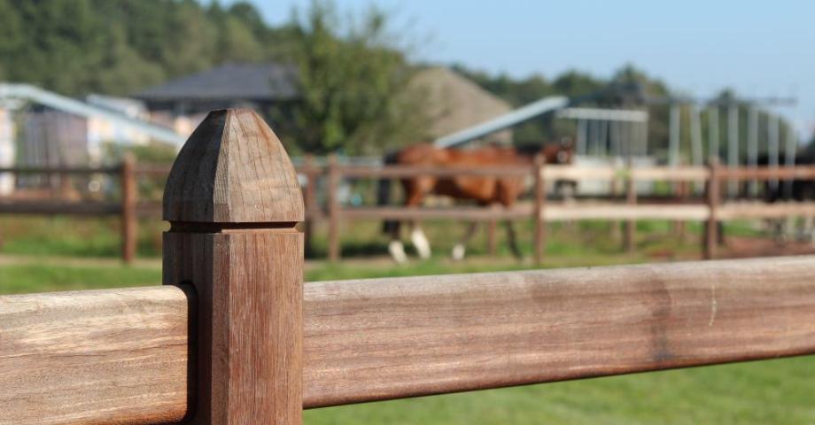 Close-up van de bovenkant van een houten paal waarop rails glijden.
