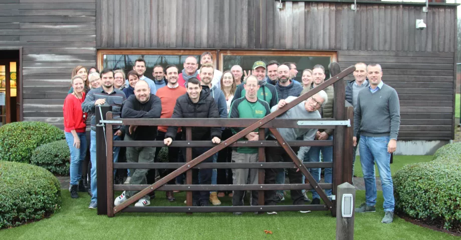 Un groupe de personnes devant un portail en bois au sommet arqué