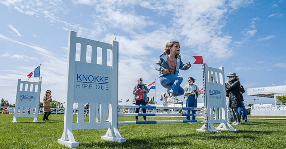 A girl jumping from a jumping obstacle