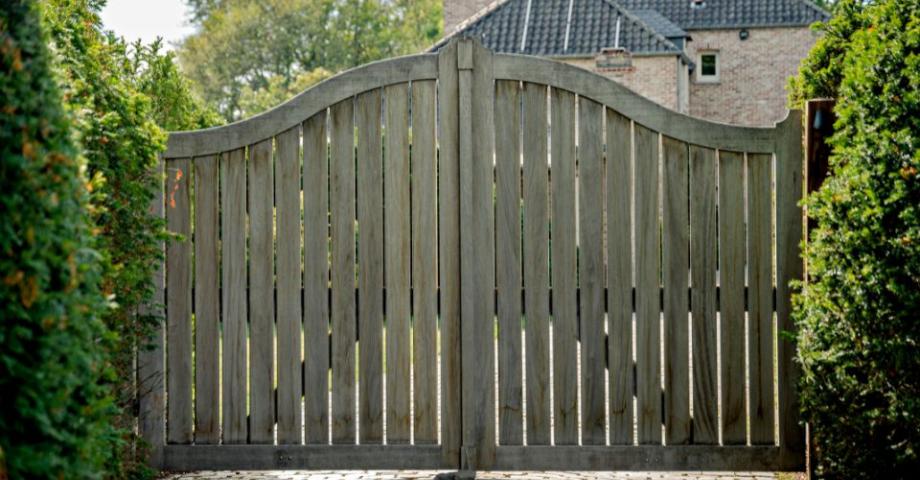 A see-through wooden driveway swing gate with a napoleon arch and vertical boards