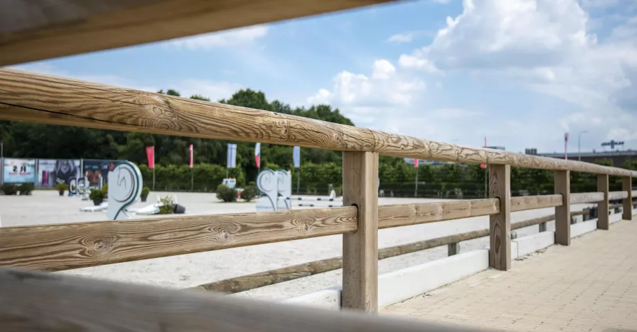 Track fencing with continuous, semicircular top rail